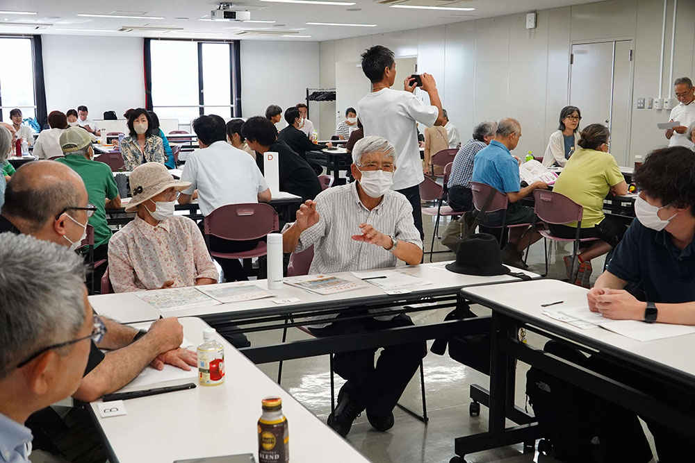 グループミーティングで意見を述べる参加者の画像